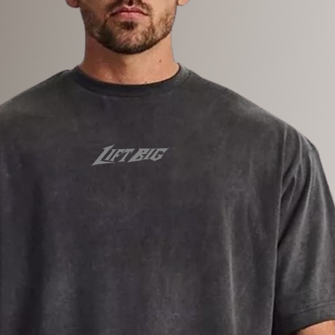 Man wearing a dark gray t-shirt with 'LIFT BIG' logo on a plain background