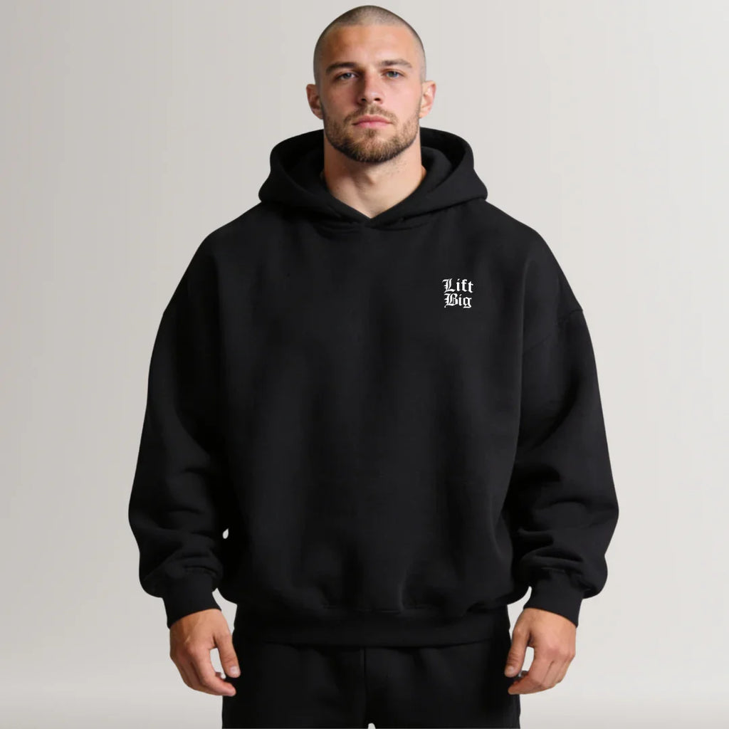 Man wearing a black hoodie with a logo on a plain background