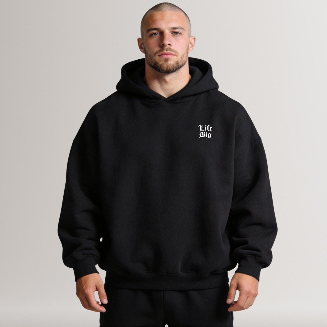 Man wearing a black hoodie with a logo on a plain background