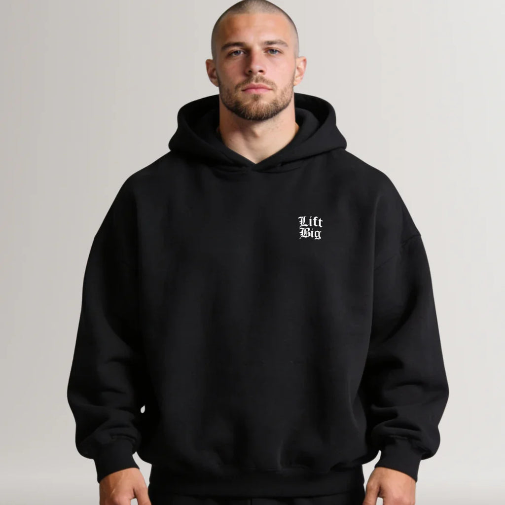 Man wearing a black hoodie with 'Lift Big' text on a plain background