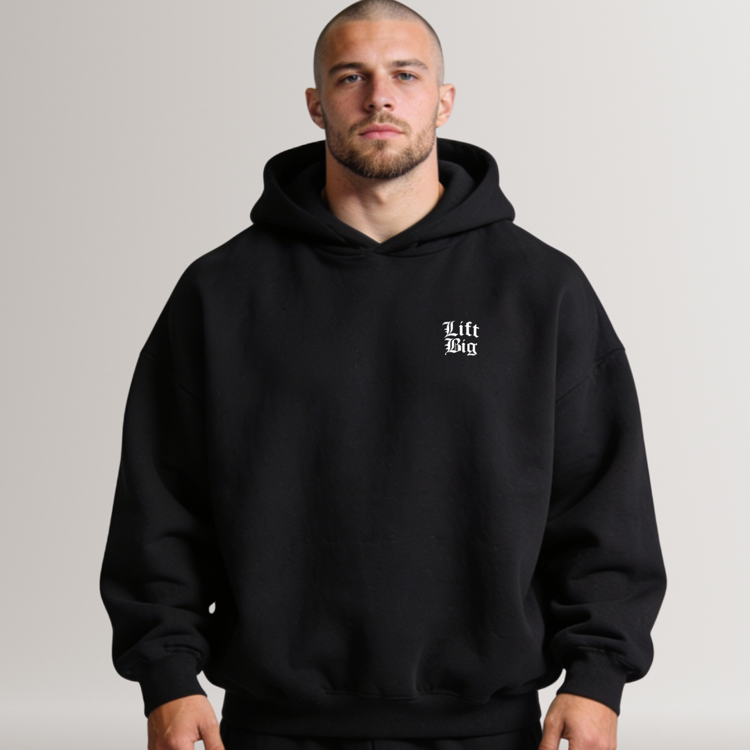 Man wearing a black hoodie with 'Lift Big' text on a plain background