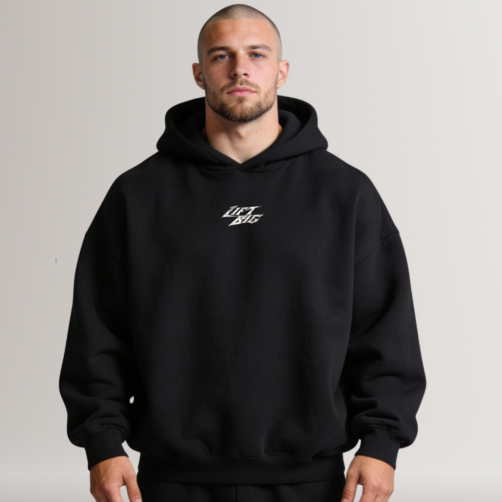 Man wearing a black hoodie with a logo on a gray background