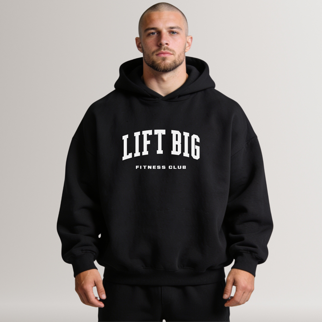 Man wearing a black hoodie with 'LIFT BIG Fitness Club' text on a plain background