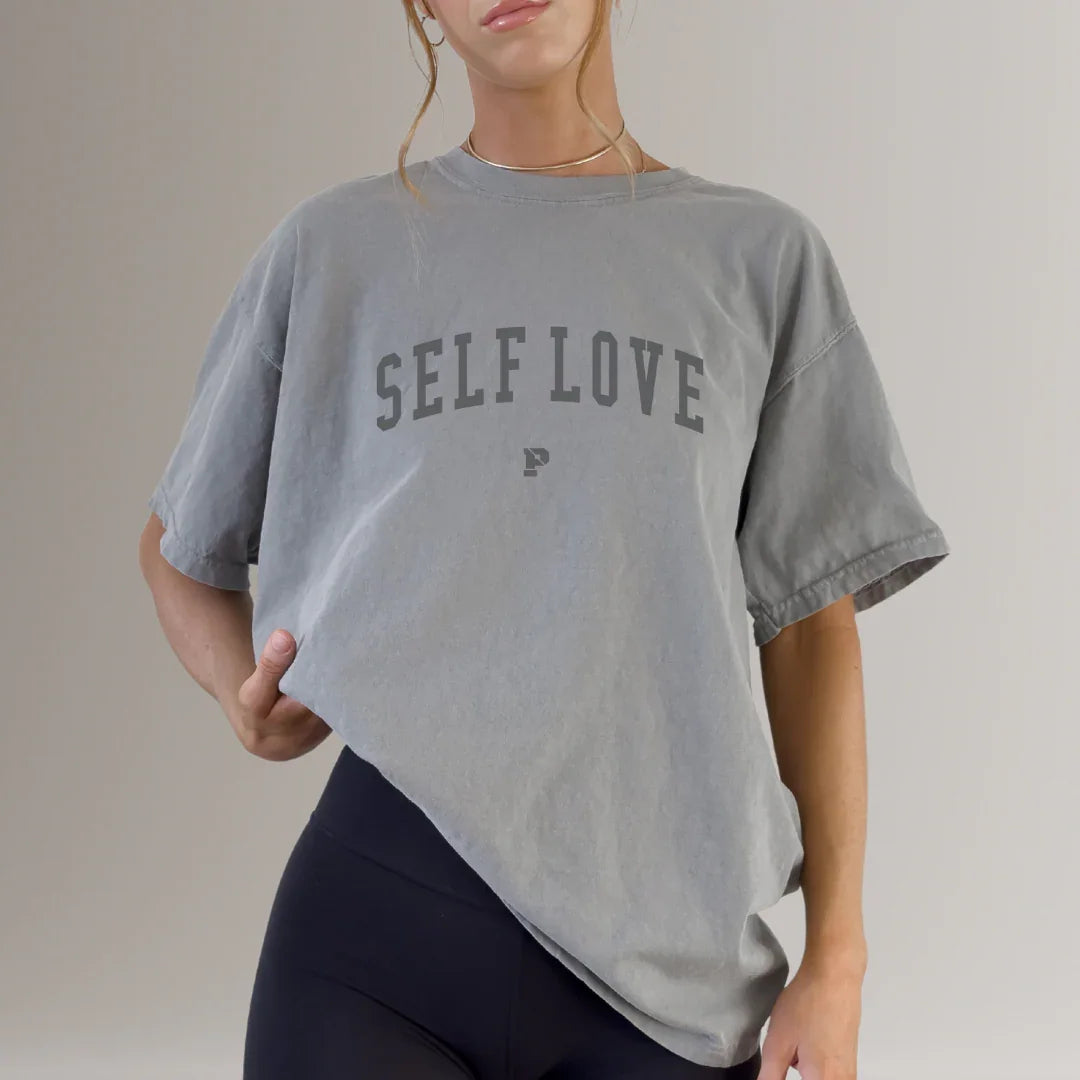 Woman wearing grey SELF LOVE fitness t-shirt with black leggings, activewear apparel